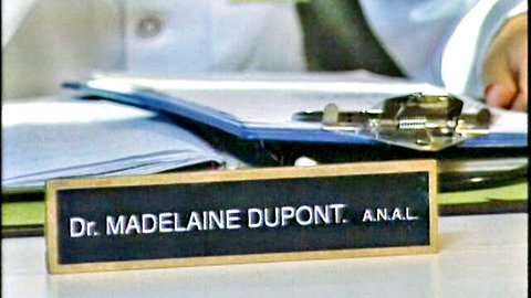Dr. Madeleine Dupont anal nameplate on medical office desk with clipboard and files