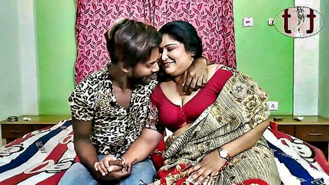 Indian mother-in-law in red saree embraces young man intimately