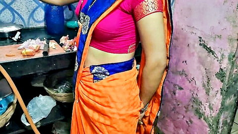 Curvy Indian housewife with big tits in tight pink blouse and orange saree posing in kitchen