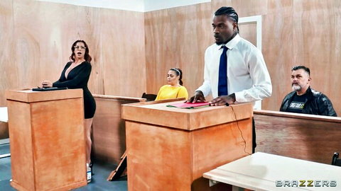 Brunette MILF lawyer with big tits in tight black dress stands at podium in courtroom with black suited man