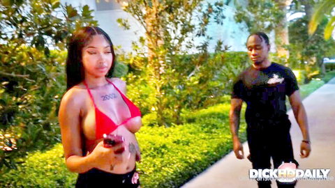 Wicca LaVey in red bikini top teasing with black stud outdoors