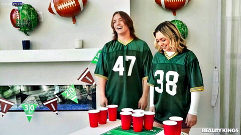 Jasmine Sherni in green football jersey with partner at game day party