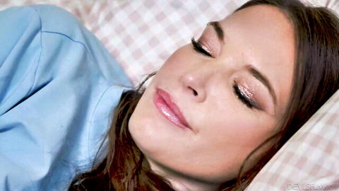 Closeup of sexy brunette with glossy lips and smoky eyes lying on checkered bed pillows