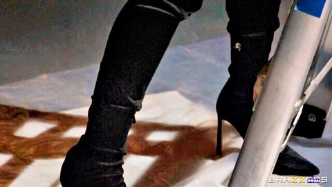 Kira Noir's sexy legs in black thigh-high boots and heels, teasing pose