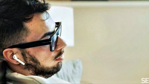 Handsome bearded man in sunglasses and earbuds, casual erotic vibe