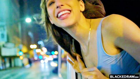 Abella Danger smiling with tongue out in blue tank top, teasing cleavage in night car scene