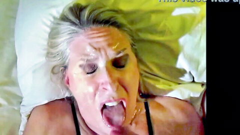 Mature blonde milf's face drenched in thick cum with tongue out and mouth wide open