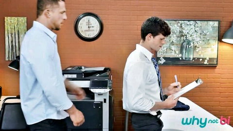 Two suited hunks in office, muscular guy operates copier while colleague reviews papers