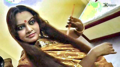 Sexy Indian babe in gold saree smiling seductively with bindi and jewelry