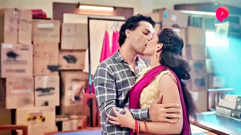 Indian housewife in red saree passionately kissing man in grey shirt in storage room