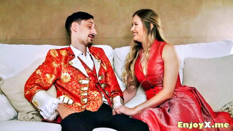 Blonde in red dress shares passionate moment with man in fancy jacket