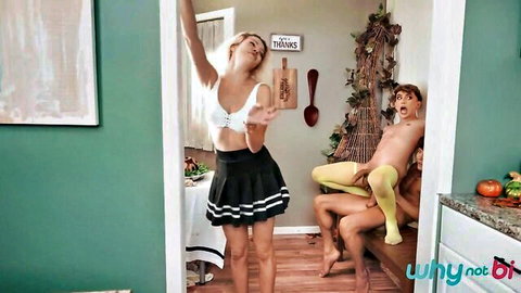 Blonde in white bra and black mini skirt teases two nude muscular guys with hard cocks in kitchen