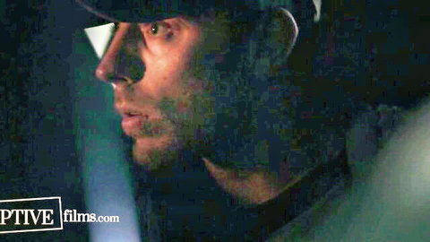 Intense close-up profile of handsome man in cap looking sideways in dark scene