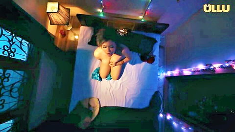 Topless Indian housewife lying naked on bed covering huge tits seductively in lingerie