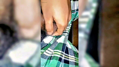 Hand tugging plaid shorts down exposing bushy pubes and small flaccid Asian cock