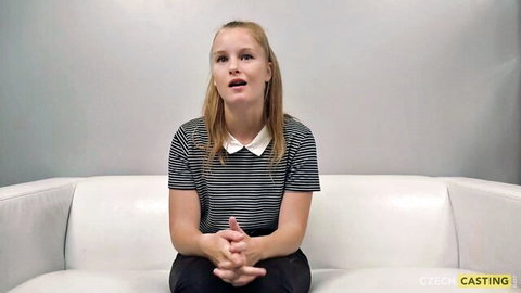 Young blonde Czech girl in striped shirt looks surprised at casting couch interview