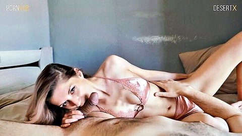 Fit brunette in pink lingerie lying on bed with teasing hand touch