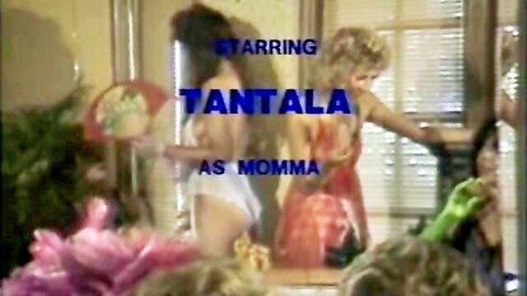 Tantala as Momma in 1984 vintage adult film Momma's Boy, busty blonde in red dress