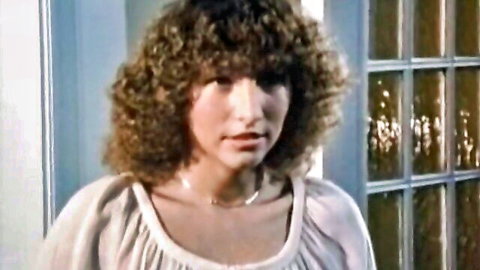 Vintage curly haired woman in loose white blouse standing seductively