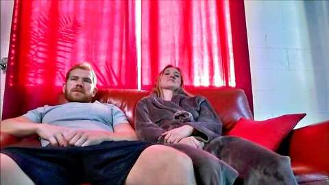 Riley Reynolds in cozy bathrobe with partner on couch, family attraction vibe
