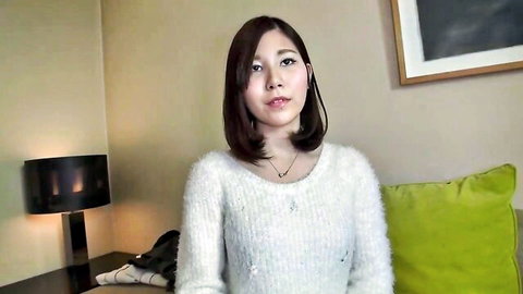 Cute Asian woman with short dark hair in fuzzy white sweater, smiling for amateur JAV teaser
