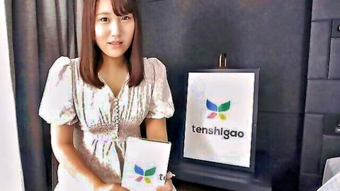 Japanese brunette model smiling in low-cut blouse holding tenshigao box
