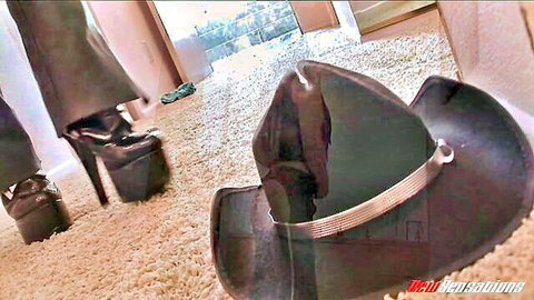 Woman's sexy platform heels with pants pulled down around ankles next to black cowboy hat on carpet