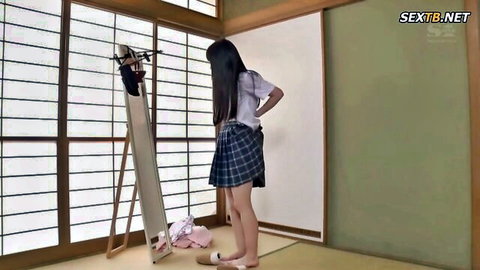 Aika Yumeno in Japanese school uniform standing before mirror, innocent pose