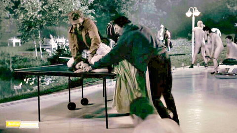 Justine Waddell restrained on table by men in historical outdoor scene