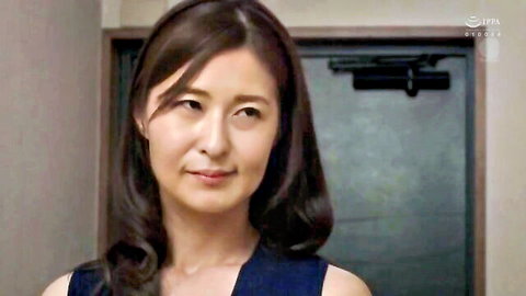 Sexy Japanese MILF teacher smiling seductively in low-cut blue top showing cleavage