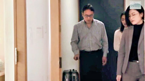 Yuri Sasahara in suited hotel hallway scene with man and women, clothed tease