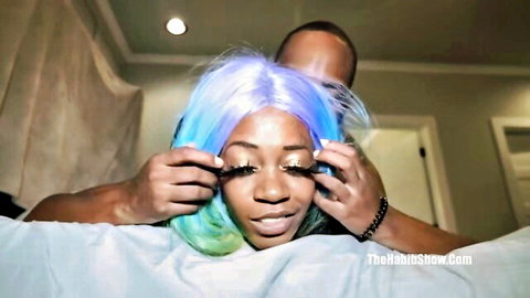 Cameron Cox with blue-green wig in intimate makeup moment with partner
