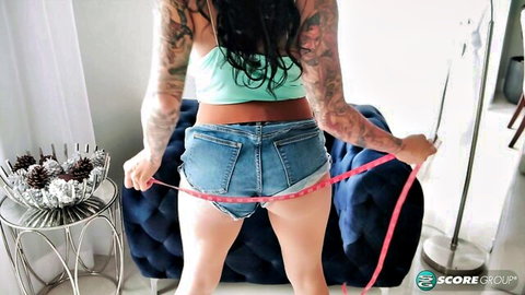 Ricki Raxxx in tiny denim shorts, measuring curvy hips and tattooed body
