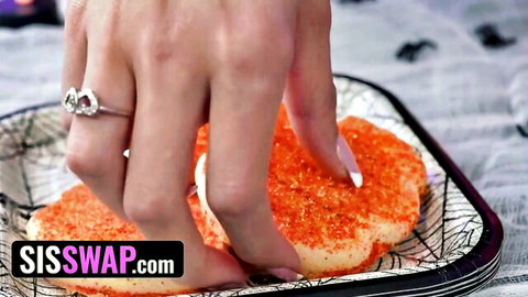 Stepsister's manicured hand with ring grabbing orange Halloween cookie