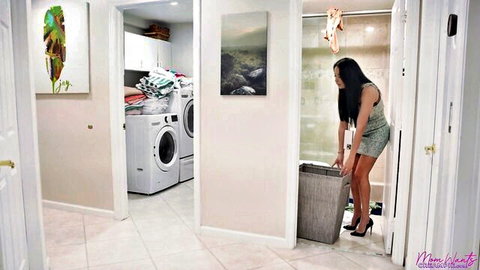 Curvy Asian stepmom in short green dress bending over laundry basket