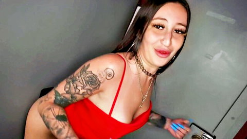 Anna Chambers tattooed in red top, smiling at gloryhole tease