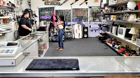 Brittney White in tight jeans and tank top at pawn shop counter