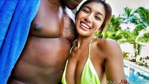 Clara Trinity smiling in yellow bikini with muscular black man poolside selfie