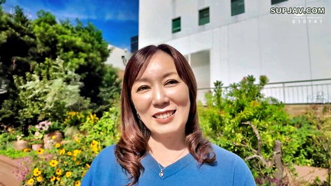 Smiling Asian MILF in blue top outdoors, secret affair vibe