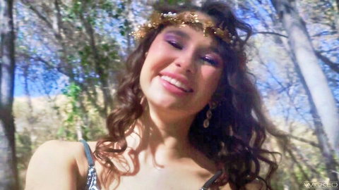Liz Jordan smiling in forest with gold flower crown, black spaghetti strap top