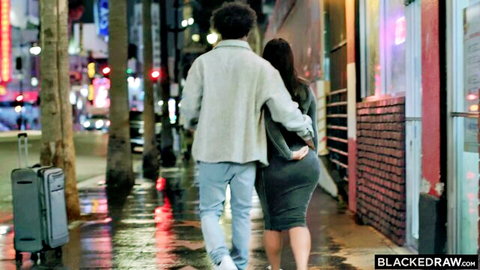 Black stud walks arm-in-arm with curvy Asian babe in tight dress on wet neon-lit street teasing her big ass.