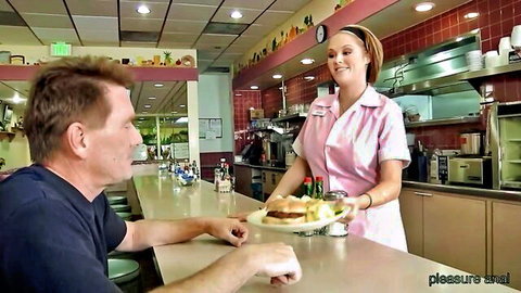 Sexy waitress in pink uniform serving burger to customer at diner counter