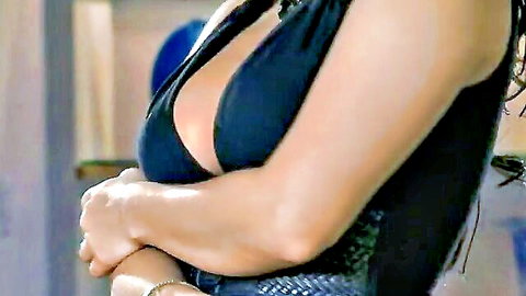 Sunny Leone posing in low-cut black dress revealing deep cleavage