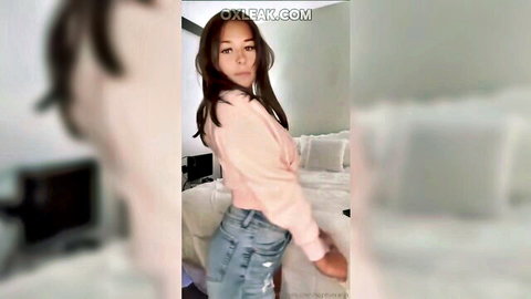 Thick brunette teen in pink hoodie and tight ripped jeans posing seductively with big juicy ass