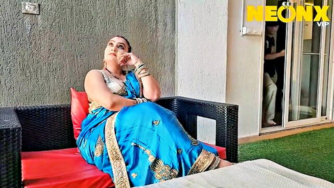 Curvy Indian babe in blue saree showing massive tits cleavage sitting pensively on balcony