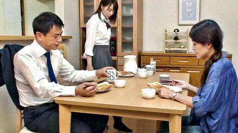 Japanese man and wife at table with standing woman serving tea and food