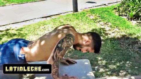 Tattooed Latino hunk shirtless in jeans doing push-ups outdoors