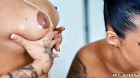 Tattooed tanned babes groping massive oiled tits with cum dripping from hard nipple