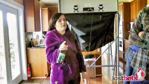 Madison in purple robe holds spray bottle in lost bets strip pod stomp game with James