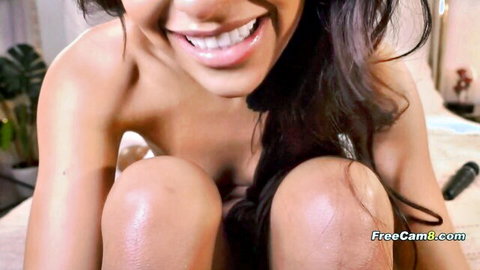 Tanned Latina smiling topless, rubbing wet pussy with dildo nearby